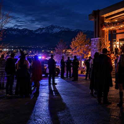 Police officers speak with costumed guests outside a Colorado Springs Halloween party.